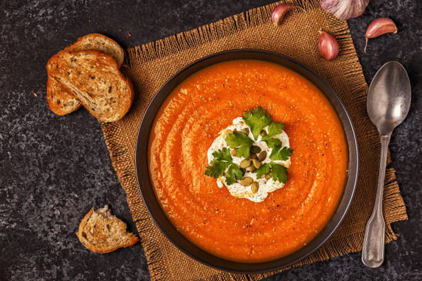 istock Pumpkin and carrot soup with cream, seeds and parsley. 855939952