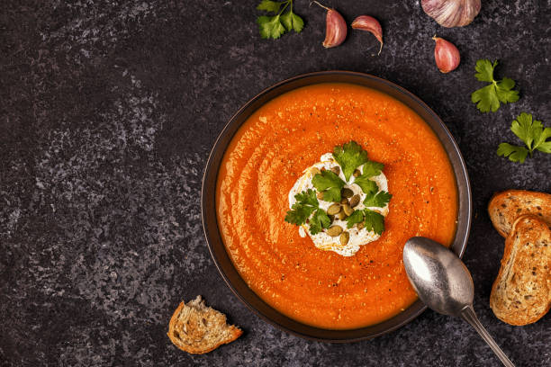 istock Pumpkin and carrot soup with cream, seeds and parsley. 855939978