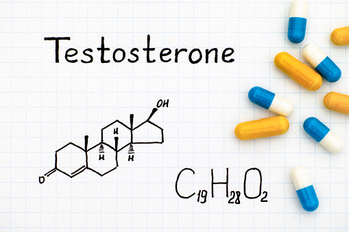Chemical formula of Testosterone with some pills. Close-up.