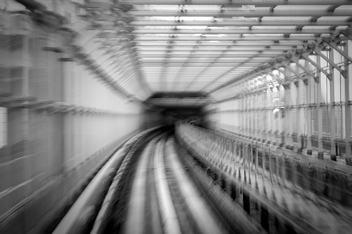 Black and white of motion blur of train moving inside tunnel in Odaiba, Tokyo, Japan
