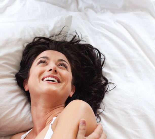 istock Smiling beautiful woman having fun in bed 855947304