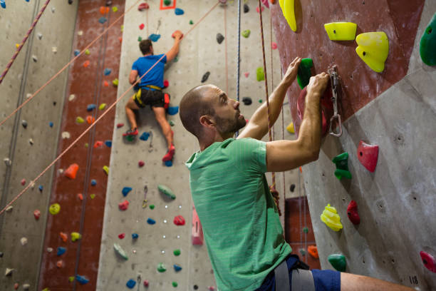 istock Fit athletes climbing wall in club 855947628