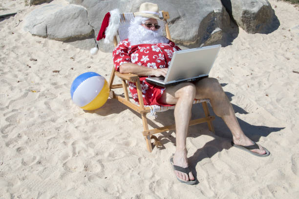istock Santa Claus working on beach chair working on laptop 855953470