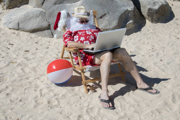 Santa clause vacationing and relax on a beach after the busy Christmas season. Isolated on white background.