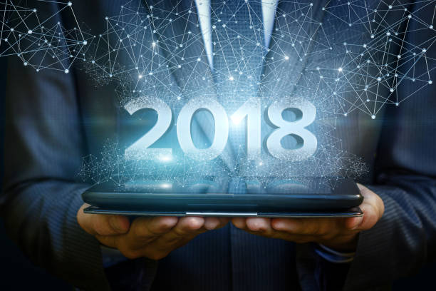 istock Businessman on tablet shows the numbers 2018. 855958600