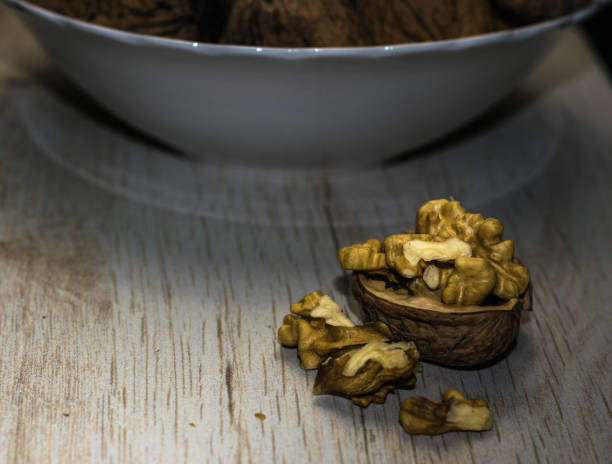 istock Walnut on a wooden surface and white bowl 855969308