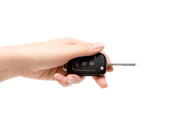 istock Female hand holds car keys on white background. 855973276