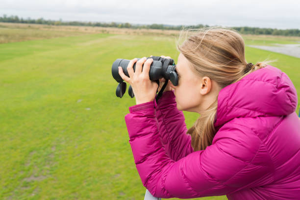istock blonde woman looks in binocular 855973316
