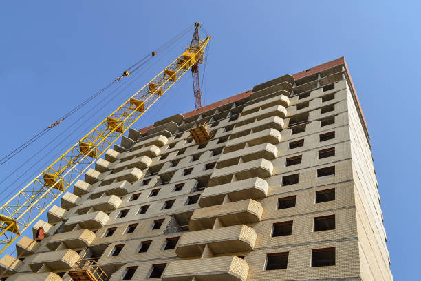 istock Building crane at the background of a multi-storey building under construction 855976330