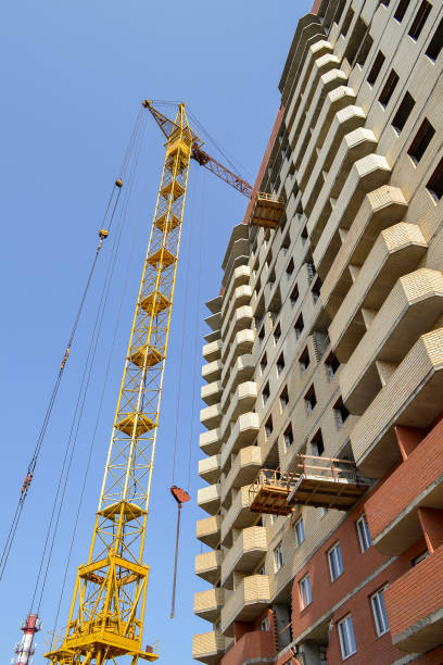 istock Building crane at the background of a multi-storey building under construction 855976374
