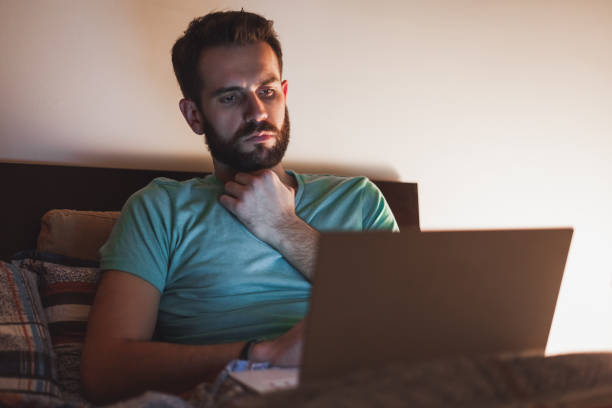 istock Young man working late in bed on a laptop 855977584
