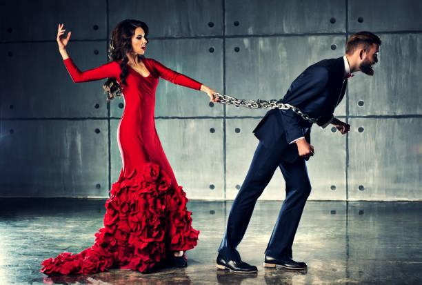 Woman holding man on heavy chain stock photo