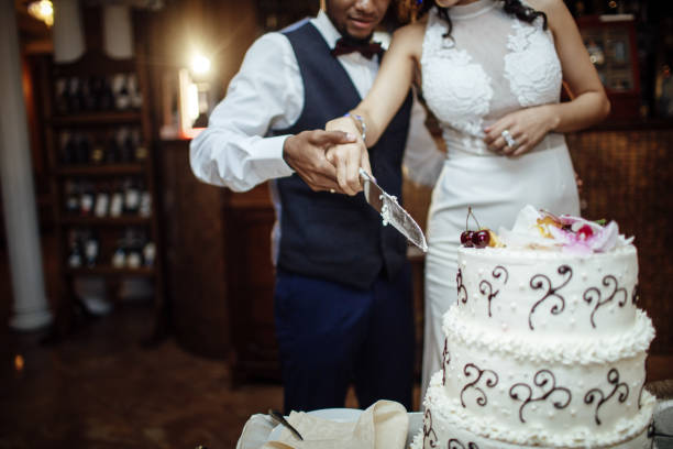 istock bride and groom cutting the wedding cake 855994632