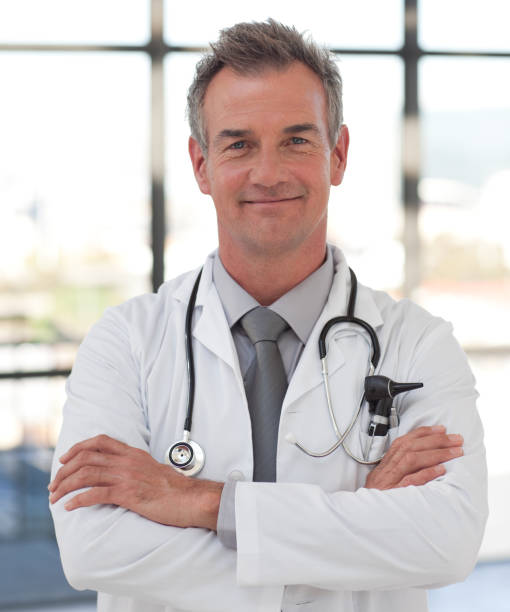 istock Elderly doctor with folded arms smiling at the camera 856000288