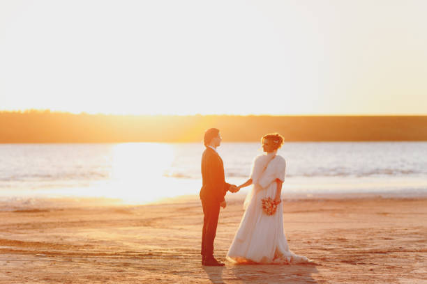 istock Groom and bride on a walk outdoors at the sea 856004254