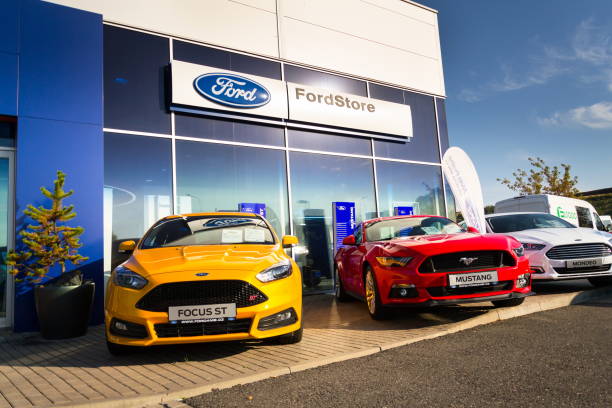 Cars in front of Ford motor company dealership building stock photo