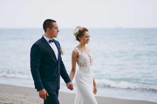 istock Groom and bride on a walk outdoors at the sea 856021388