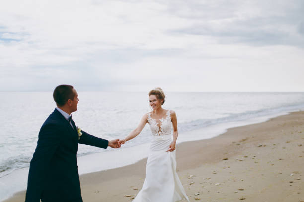 istock Groom and bride on a walk outdoors at the sea 856021868