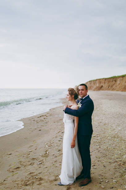istock Groom and bride on a walk outdoors at the sea 856024384