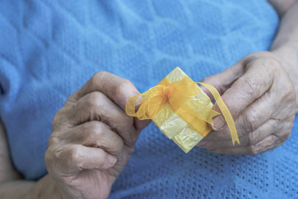 istock closeup of wrinkled hands holding a gift box 856024402