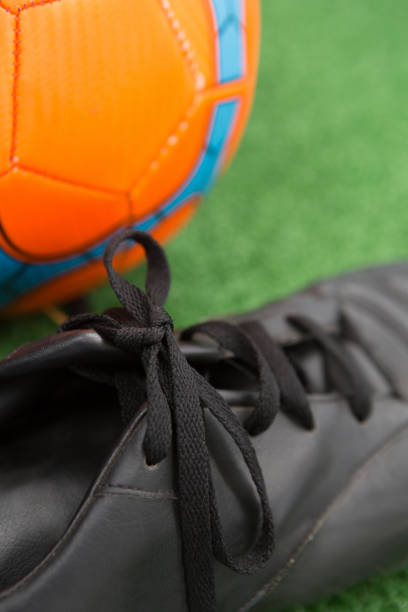 istock Football and cleats on artificial grass 856027668