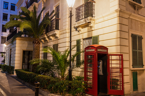 Gibraltar City Hall and red phone booth at night. Gibraltar.