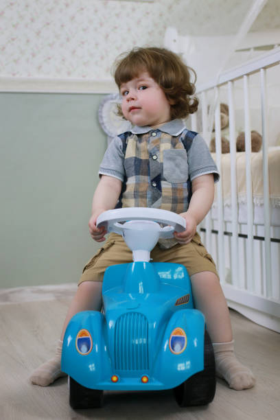 istock litle boy sit on a toy car 856030752
