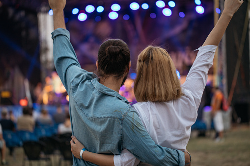 Happy young couple embracing and enjoying at music festival.