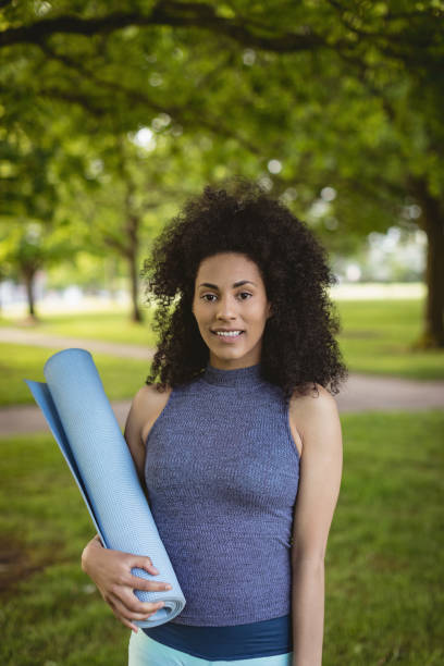 istock Woman holding exercise mat in the park 856039946