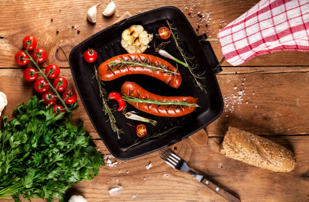 istock Grilled sausages in a pan on wooden background 856045848