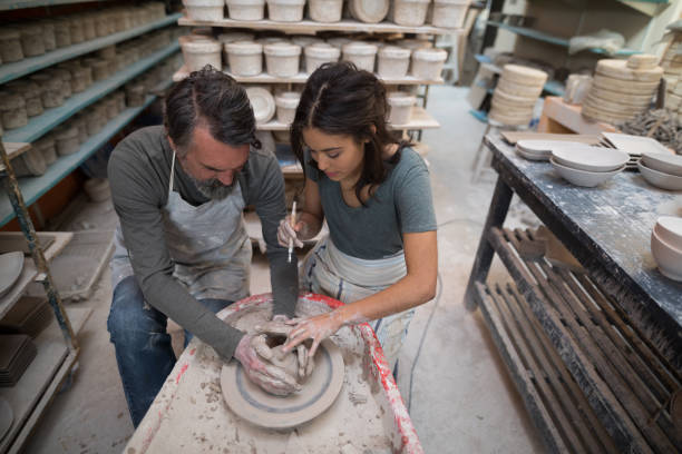 istock Male potter assisting female potter 856048994