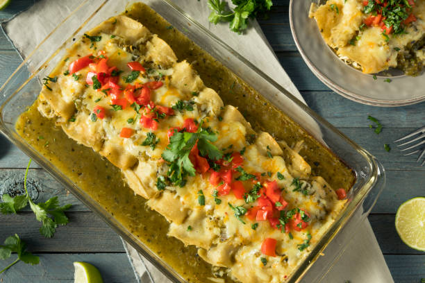 Homemade Green Chicken Enchiladas Homemade Green Chicken Enchiladas with Cilantro and Sauce enchilada stock pictures, royalty-free photos & images