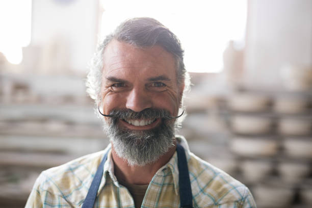 istock Happy male potter standing in pottery workshop 856053908
