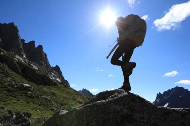 woman with backpack hiking in mountains