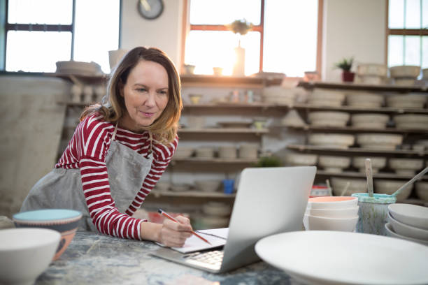 istock Female potter checking the orders from laptop 856056898