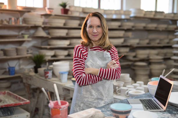 istock Portrait of female potter standing at worktop 856058842