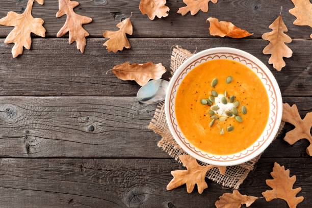 zupa z dyni z orzechów maślanych, scena stołu z jesiennymi liśćmi - thanksgiving vegetarian food pumpkin soup zdjęcia i obrazy z banku zdjęć