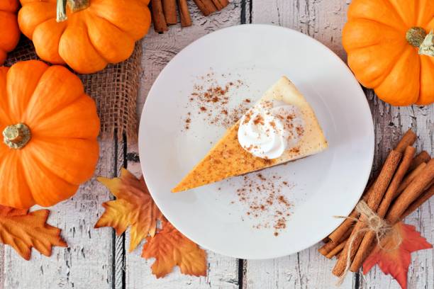 fetta di cheesecake di zucca, scena aerea su legno bianco - cheesecake foto e immagini stock