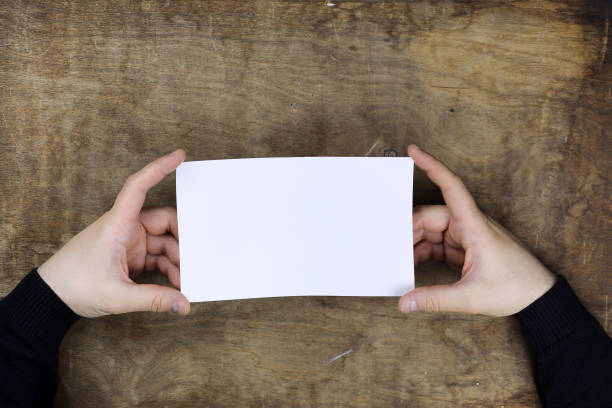 istock male hands holding a white blank sheet of paper 856077222