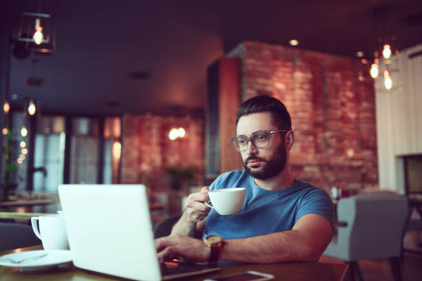 istock Young Hipster Freelancer Drinking Coffee and Working In Cafe Restaurant 856079886