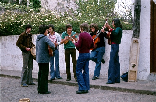 Valencia, Province of Valencia, Spain, 1977. Street musicians play together in circles on their Spanish guitars in a street in Valencia. One of the musicians sets the beat with a drum.