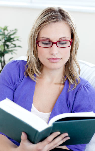 istock Young woman with glasses reading a book 856094098