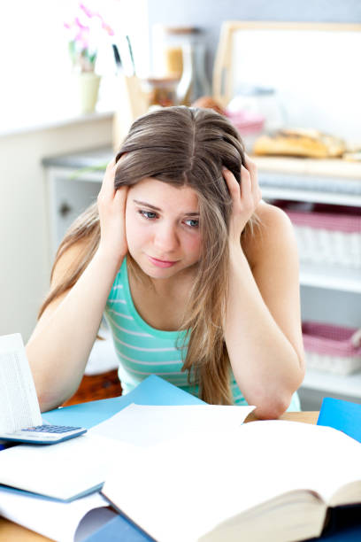 istock Stressed female teenager studying in the kitchen 856094658