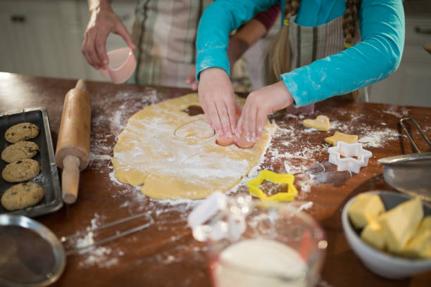 istock Mother and daughter preparing cookies in kitchen 856098624