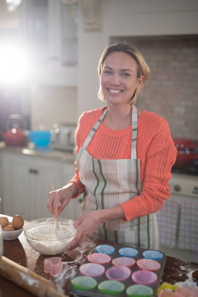 istock Smiling woman mixing eggs and wheat flour in a bowl 856101570