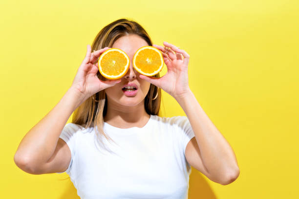 istock Happy young woman holding oranges halves 856101584