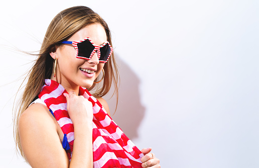 Happy young woman with USA national holiday accessories