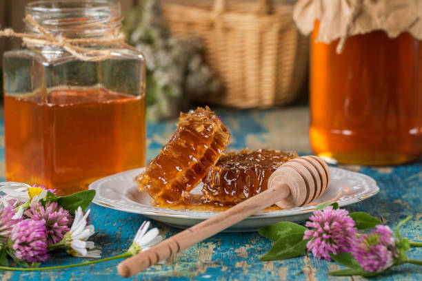 istock Two honey pots with honeycomb  on a wooden table 856105028