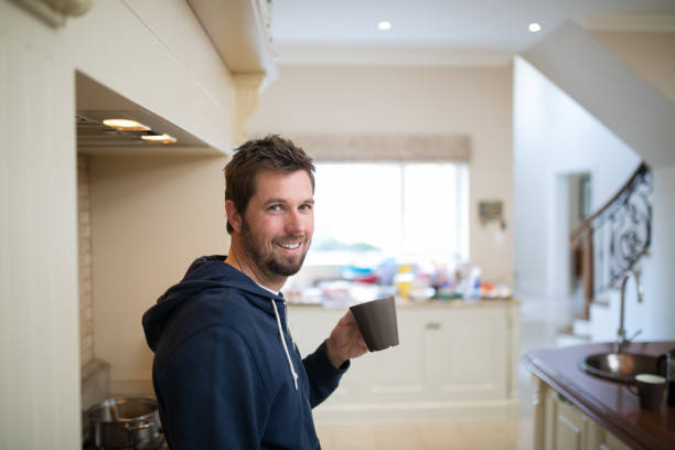 istock Man holding a cup of coffee at home 856105552