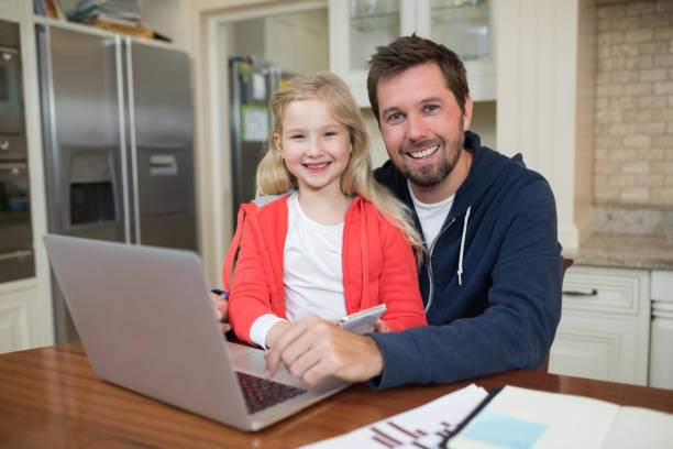istock Father and daughter working on laptop 856105826